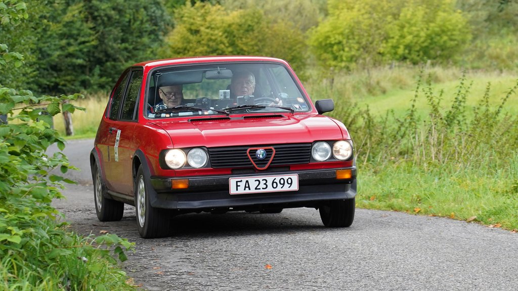 Sport- klassen blev vundet af Niels Christian Madsen, Brøndby / Olav Madsen, Flyinge, Alfa Romeo Alfasud, 1,5 Ti QV, årgang 1982, som her er på vej gennem Kærbølling Huse ved Vejle.
(Foto: Viggo Johansen, rallypics.dk)
